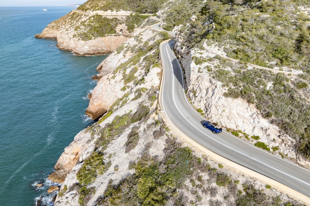 MINI Countryman E a circular na estrada no meio de paisagem natural.